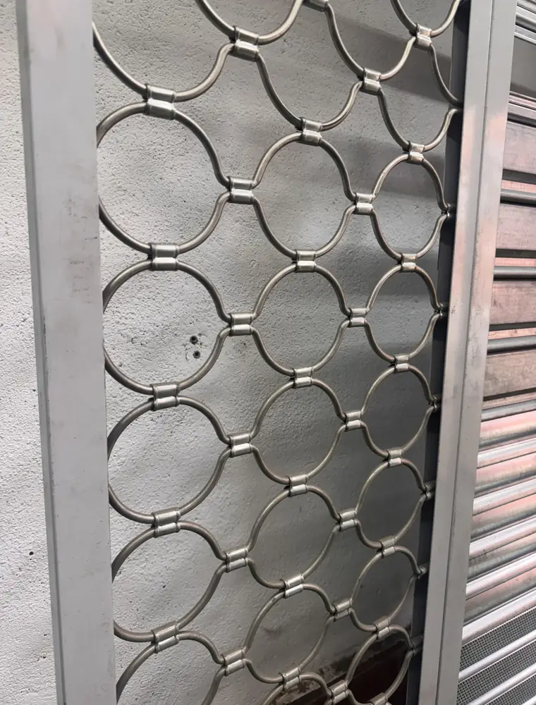 Panel de cierre de ballesta de varilla metálica formando aros entrelazados